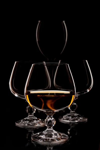 Κρασί και το κονιάκ glasseson το μαύρο φόντο — Φωτογραφία Αρχείου