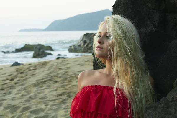 Γυναίκα ομορφιά ξανθιά στην παραλία κοντά στο βράχο — Φωτογραφία Αρχείου