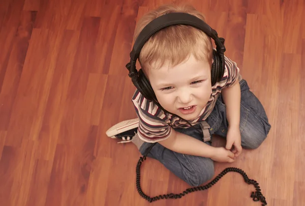 Funny child listening music in headphones — Stock Photo, Image