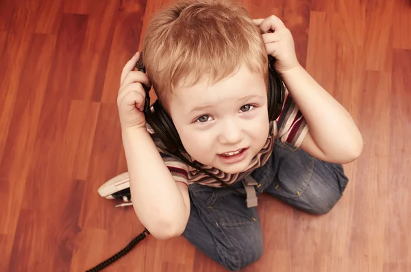 Menino pequeno ouvindo música em fones de ouvido — Fotografia de Stock