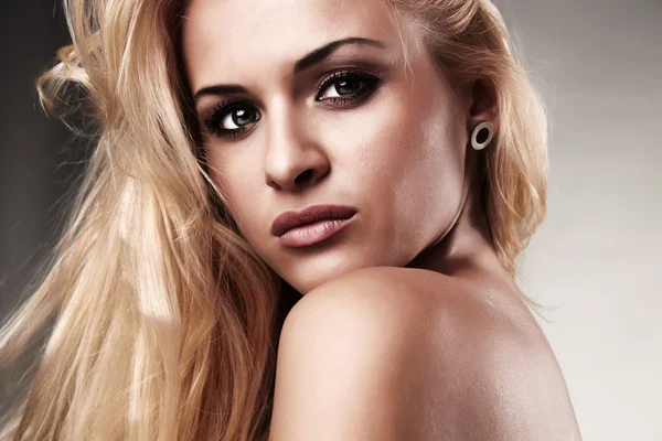 Portret van mooie blonde vrouw. de achtergrond licht — Stockfoto