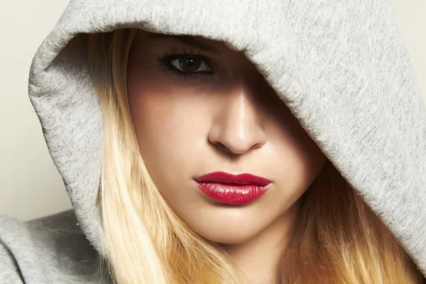 Beautiful blond woman in hood. red lips. — Stock Photo, Image