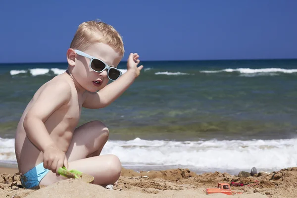 Dítě hraje na pláži v písku — Stock fotografie
