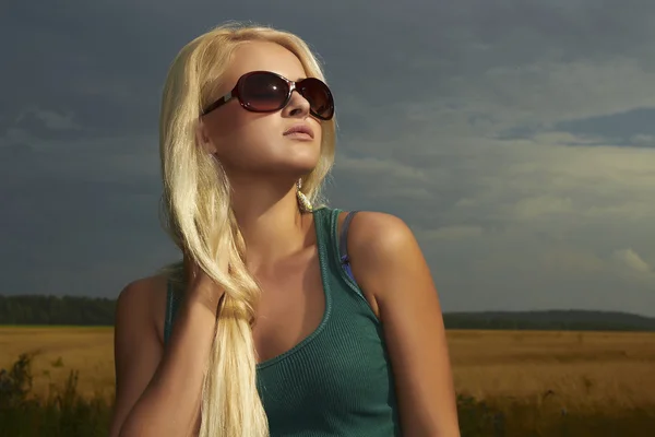 Hermosa chica rubia en el field.beauty woman.sunglasses. naturaleza fondo —  Fotos de Stock