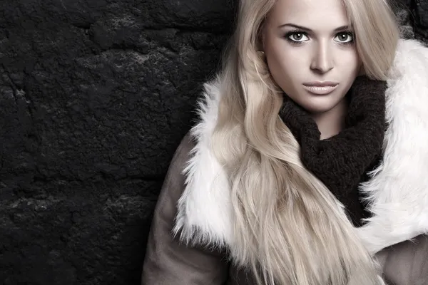 Beautiful blond woman in fur near bricks wall. winter fashion — Stock Photo, Image