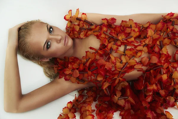 Schöne sexy blonde Frau im Bad mit orangefarbenen Blumen — Stockfoto