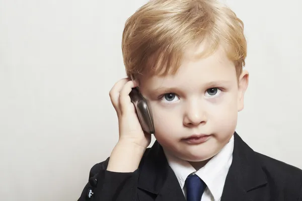 cep telefonu ile iş elbiseli küçük bir çocuk. yakışıklı çocuk. şık çocuk
