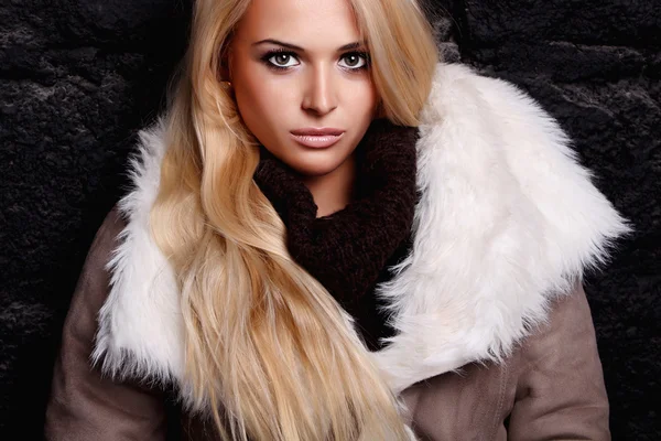 美丽的金发女人在砖壁附近的毛皮。冬季时尚 — 图库照片
