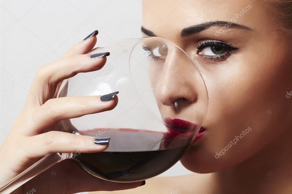 Beautiful blond woman drinking red wine.make-up.red lips