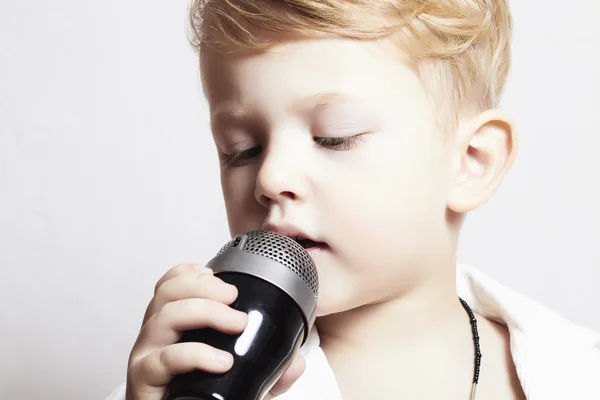 Lille dreng synger i microphone.child i karaoke.music - Stock-foto