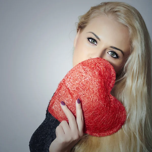 Bella donna bionda con cuore rosso. Bellezza. Tieni il simbolo dell'amore. San Valentino. in abito nero — Foto Stock