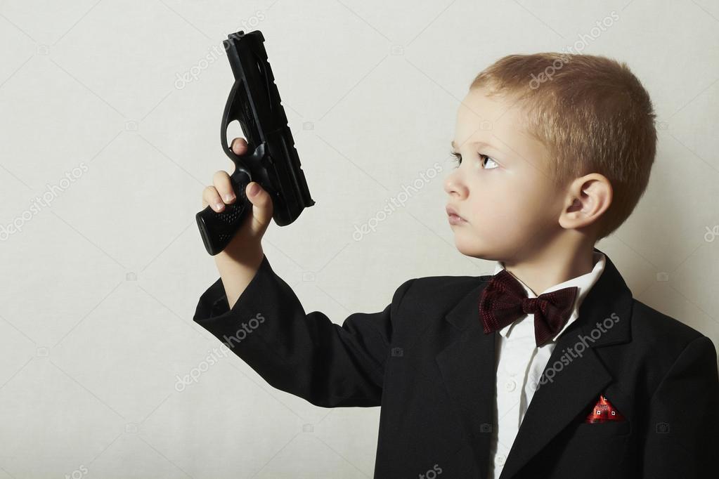 Little James Bond. Fashionable Little Boy in Bow tie.Stylish Agent. Fashion Children. 4 Years Old Child in Black Suit. Elegance Handsome Boy with Gun. Stock ©EugenePartyzan