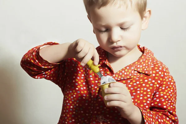 Kleine knappe jongen eet yoghurt. hongerig kind met lepel. schoonheid en voedsel. maaltijd — Stockfoto