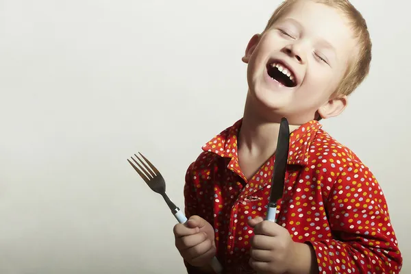 Petit garçon drôle et beau avec fourchette et couteau. Enfant affamé. Un gamin souriant. Tu veux manger ? — Photo