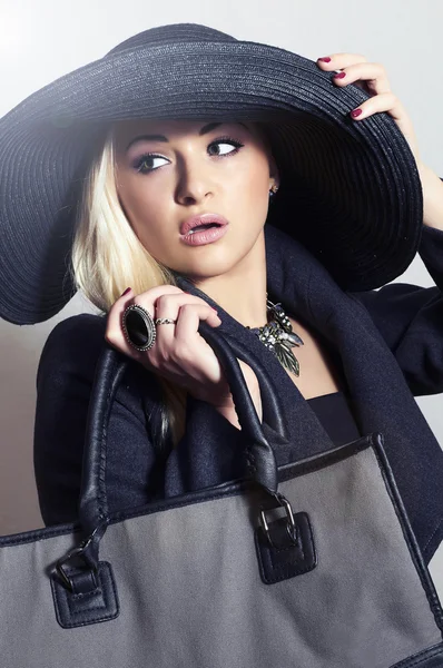 Hermosa mujer rubia con sombrero negro. Dama de moda en Topcoat. Elegance Beauty Girl con bolso. Compras primavera — Foto de Stock