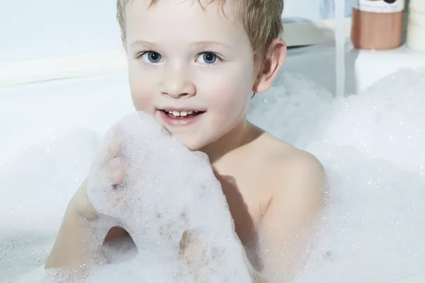 Lächelnder kleiner Junge in der Badewanne. Lustiges Kind im Schaum — Stockfoto