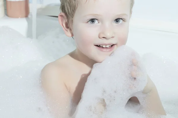 Sonriente niñito en el baño.Divertido niño en espuma — Foto de Stock