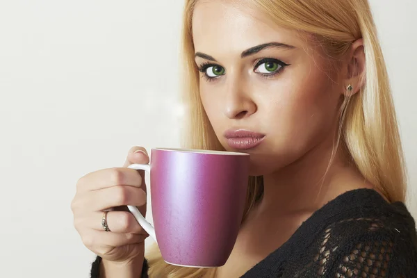 Hermosa rubia bebiendo café. Una taza de té. Bebida caliente. Vestido negro — Foto de Stock