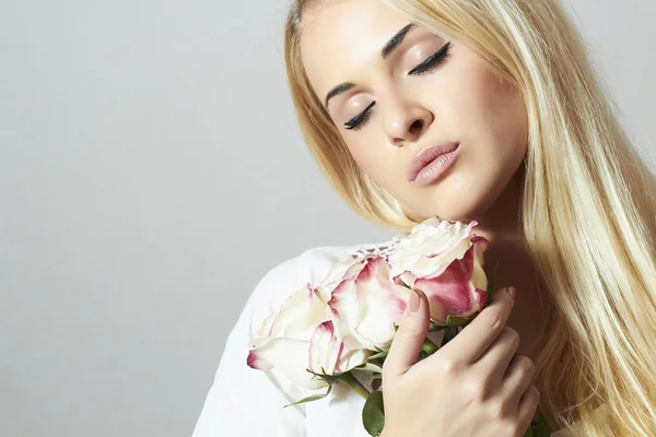 Όμορφη ξανθιά γυναίκα με flowers.girl και roses.close-up κατακόρυφο. Λευκό λουλούδι — Φωτογραφία Αρχείου