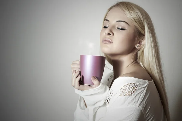 아름 다운 여 자가 커피를 마시는입니다. 차 한잔입니다. 뜨거운 음료입니다. 금발 소녀 — 스톡 사진