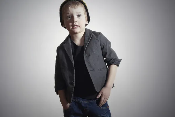 El chiquitín a la moda en la gorra y los vaqueros. El chiquitín de estilo en la chaqueta. Moda niños . —  Fotos de Stock