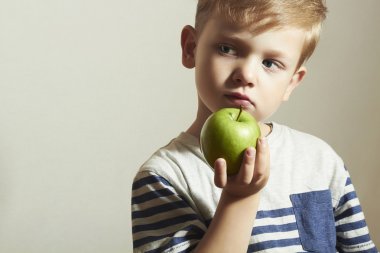 Yeşil elma apple.little yakışıklı çocukla çocuk tutar. sağlık gıda. meyve. yemeğin keyfini çıkarın