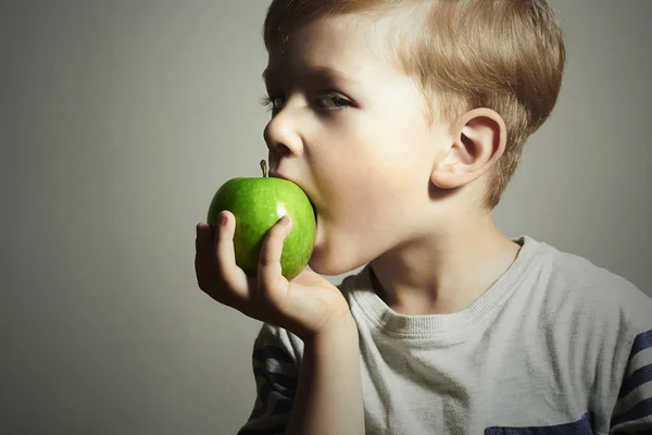 Lustiges Kind beim Apfelessen. Kleiner hübscher Junge mit grünem Apfel. Gesunde Ernährung. Früchte. Mahlzeit genießen — Stockfoto