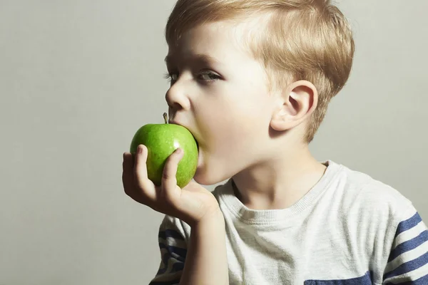 Kind isst Äpfel. Kleiner hübscher Junge mit grünem Apfel. gesunde Ernährung. Früchte. Mahlzeit genießen — Stockfoto