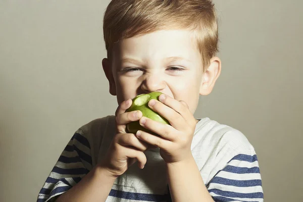 재미있는 아이가 사과를 먹고 있어요. 사과가 초록색인 작은 잘생긴 소년이죠. 건강 식품. 열매. 식사를 즐기라 — 스톡 사진