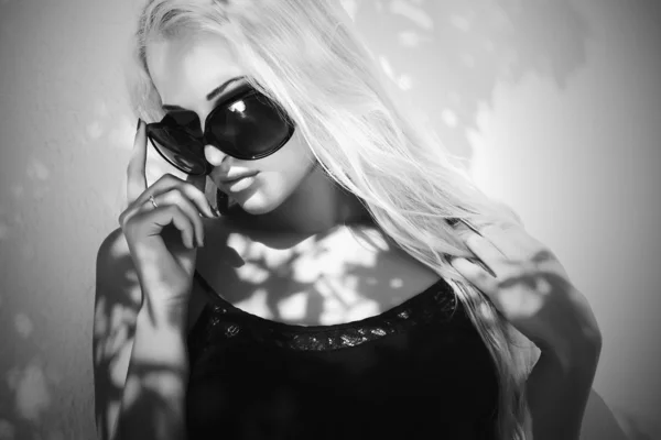 Mooie vrouw in sunglasses.shadows op de face.blond meisje in de buurt van de wall.fashion zwart-wit — Stockfoto