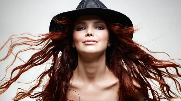帽子の美しい幸せな女性 巻き毛の長い赤い髪 健康的な髪の笑顔の女の子の美しさの肖像 — ストック写真