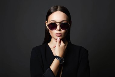 Güneş gözlüklü seksi bir kadının moda portresi. Takım elbiseli güzel kız.