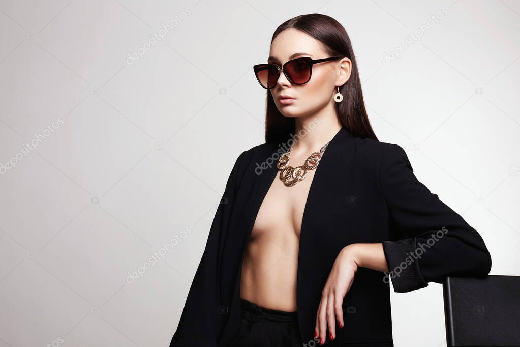 fashion portrait of beautiful sexy woman in sunglasses and jewelry. beautiful girl in gold accessories