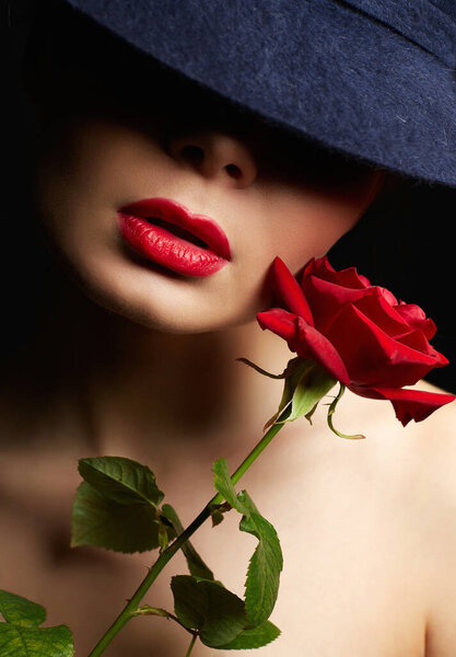 Beautiful young Woman In Hat and Flower. Lovely girl with make-up and Red Rose. beauty portrait