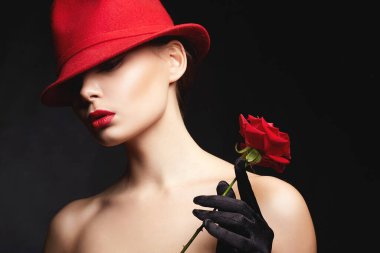 Kırmızı şapkalı ve çiçekli güzel genç bir kadın. Makyajlı ve Rose 'lu güzel bir kız. güzellik portresi