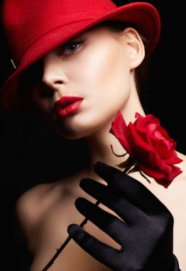 Kırmızı şapkalı ve çiçekli güzel genç bir kadın. Makyajlı ve Rose 'lu güzel bir kız. güzellik portresi
