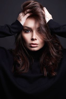 Güzel genç bir kadın. Makyajlı ve kıvırcık saçlı şehvetli güzel kız.