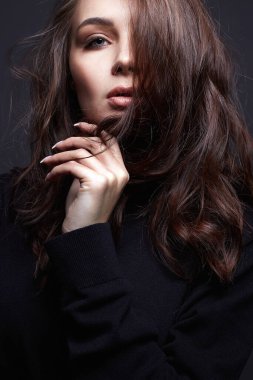 Güzel genç bir kadın. Makyajlı ve kıvırcık saçlı şehvetli güzel kız.