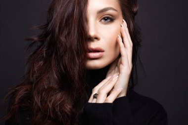 Güzel genç bir kadın. Makyajlı ve kıvırcık saçlı şehvetli güzel kız.