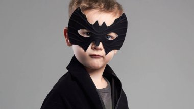 Maskeli küçük çocuk. Karnavaldaki çocuk kostümü giymiş. Stüdyo resmi