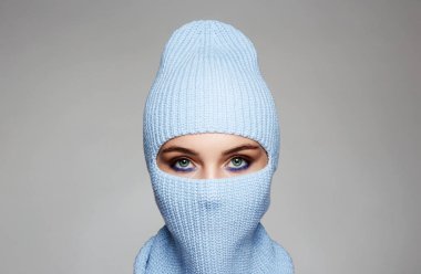 Mavi kar maskeli kızın güzel gözleri. Yeni Şapka stili. Gri Arkaplan Üzerindeki Güzel Kadın Maskesi