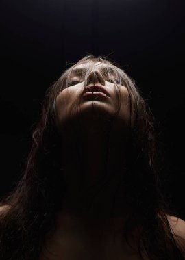 Aydınlık altındaki genç, ıslak kadın. Islak saçlı güzel kız.