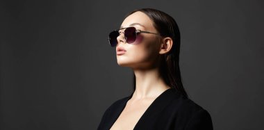 Güneş gözlüklü seksi bir kadının moda portresi. Takım elbiseli güzel kız.