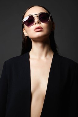 Güneş gözlüklü güzel bir kadının moda portresi. Takım elbiseli ve gözlüklü güzel kız.