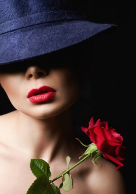 Şapkalı ve Çiçekli Güzel Genç Kadın. Makyajlı ve kırmızı güllü güzel bir kız. güzellik portresi