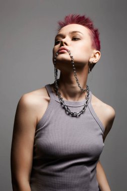 Kısa saçlı ve zincirli kolyesi olan güzel bir kadın. Mücevherli güzel seksi manken kız. Pembe Saç Tarzı