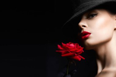 Şapkalı ve Çiçekli Güzel Genç Kadın. Makyajlı ve kırmızı güllü güzel bir kız. güzellik portresi