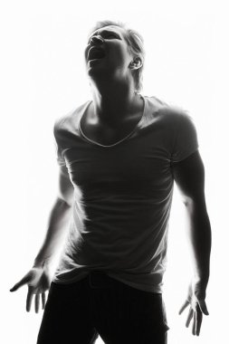 Screaming Man. Silhouette portrait of a man in studio isolated white background. Emotion boy in a shirt