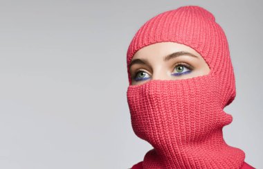 beautiful eyes of girl in red balaclava Hat. Trendy Mask on pretty woman