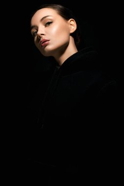 portrait of beautiful young woman in dark studio. pretty girl weared Hoodie